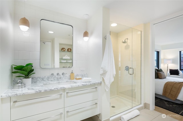 bathroom featuring walk in shower, tile walls, vanity, tile patterned flooring, and backsplash