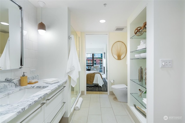 bathroom featuring vanity, toilet, a shower with shower door, and tile patterned flooring