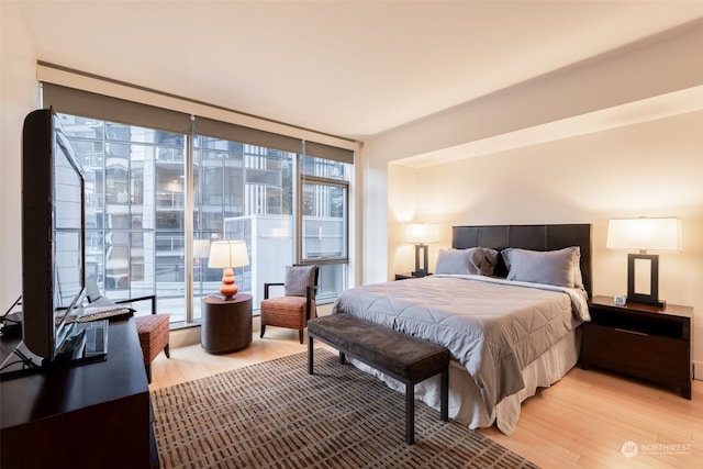 bedroom featuring floor to ceiling windows and light wood-type flooring