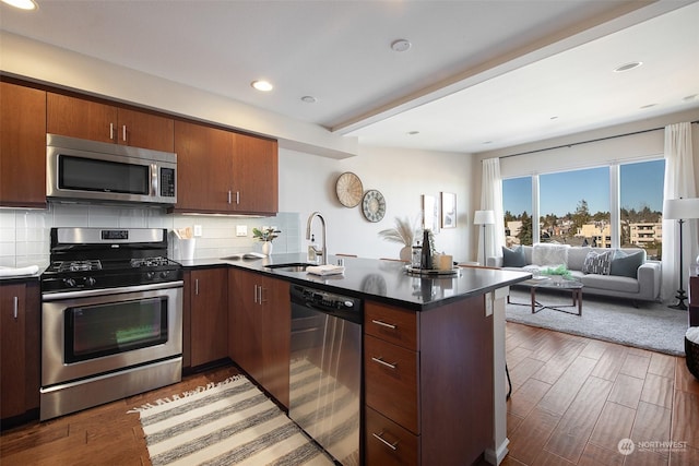 kitchen with stainless steel appliances, dark hardwood / wood-style floors, sink, and decorative backsplash