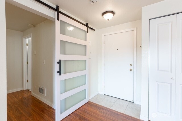 300 10th Ave Unit A203, Seattle, WA 98122 - entryway featuring a barn door, light wood-type flooring, and baseboards