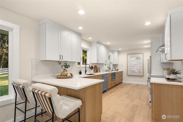 kitchen with sink, white cabinets, and a kitchen bar