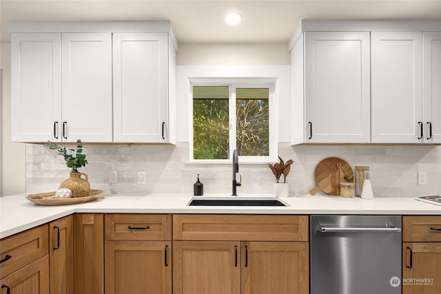 kitchen featuring dishwasher, white cabinetry, sink, and decorative backsplash