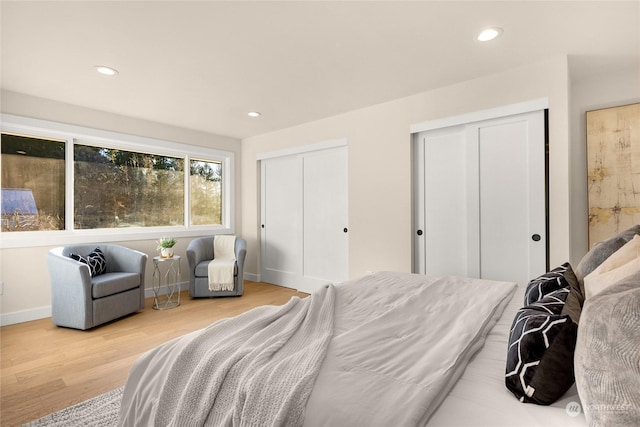 bedroom featuring multiple closets and hardwood / wood-style floors