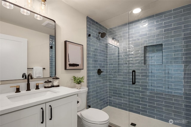 bathroom with vanity, toilet, and a shower with shower door