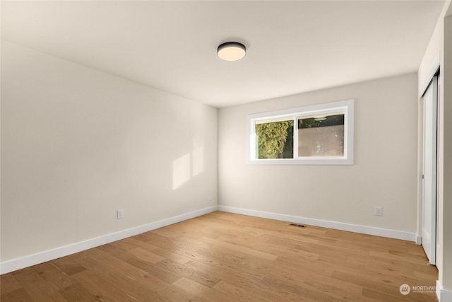 unfurnished bedroom featuring light hardwood / wood-style flooring and a closet