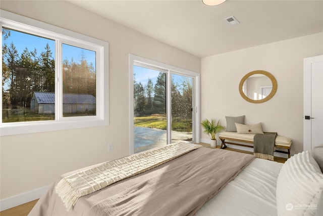 bedroom with access to exterior and hardwood / wood-style floors