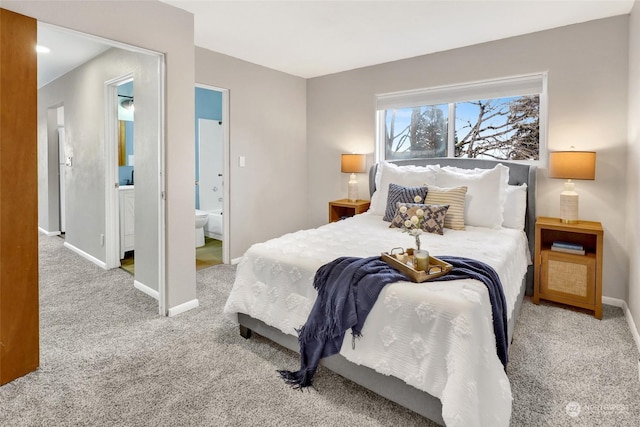 bedroom with light carpet and ensuite bath