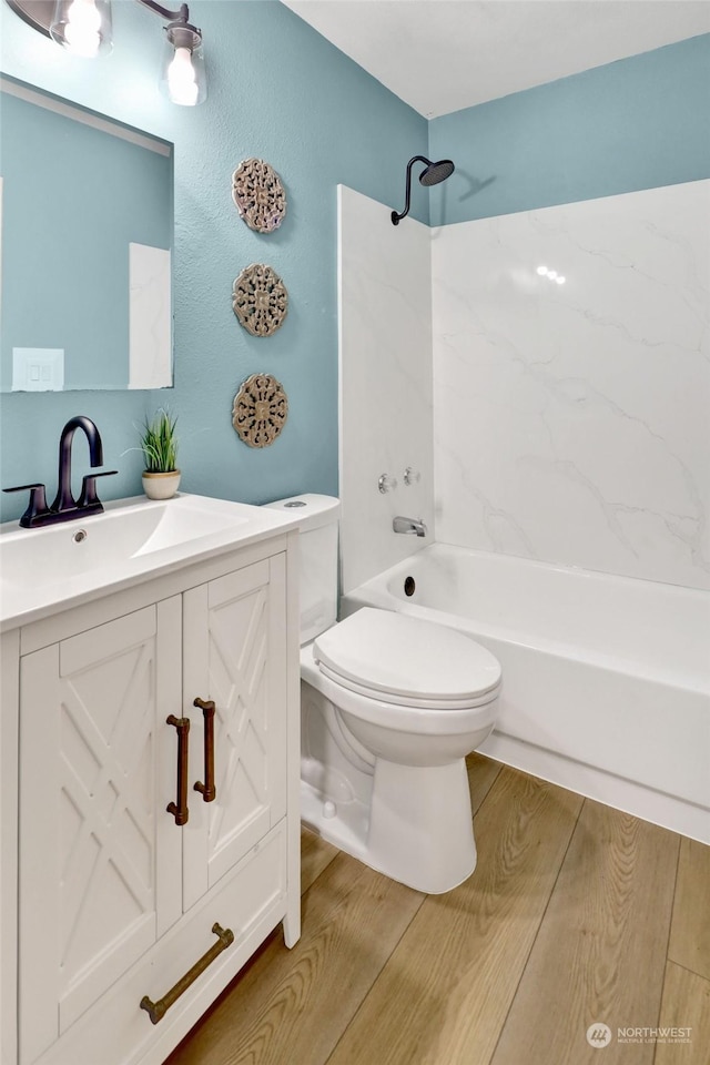 full bathroom featuring wood-type flooring, shower / bath combination, toilet, and vanity