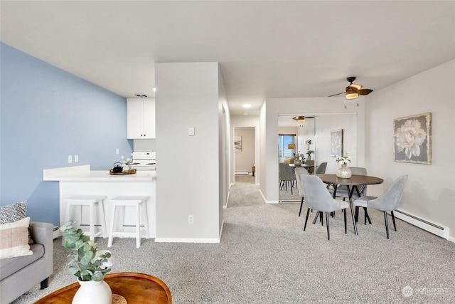 carpeted dining area featuring ceiling fan and a baseboard heating unit