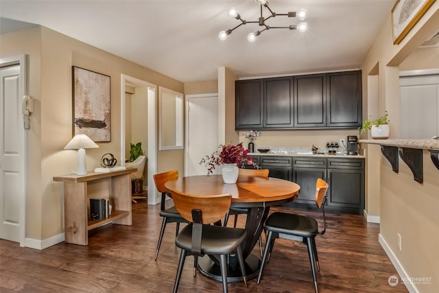 dining area with dark wood-type flooring and an inviting chandelier