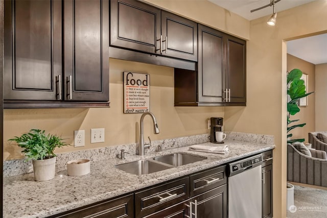 kitchen with dishwasher, sink, light stone counters, and dark brown cabinetry