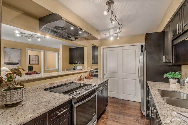 kitchen with dark brown cabinetry, sink, extractor fan, appliances with stainless steel finishes, and light stone countertops