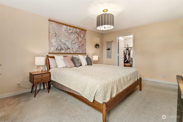 bedroom featuring a walk in closet, carpet flooring, and a closet