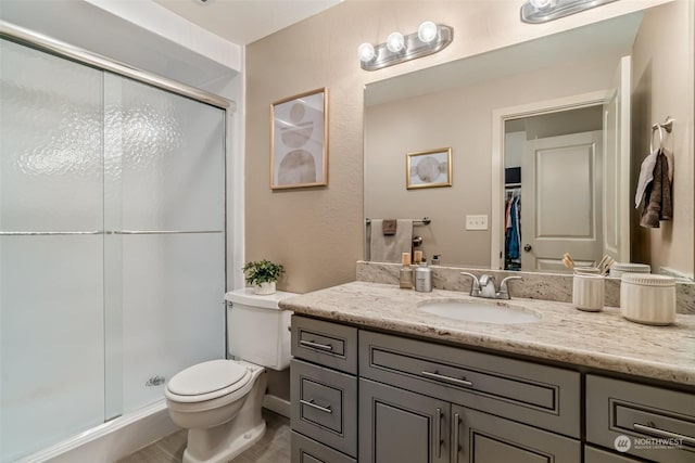 bathroom with vanity, an enclosed shower, and toilet