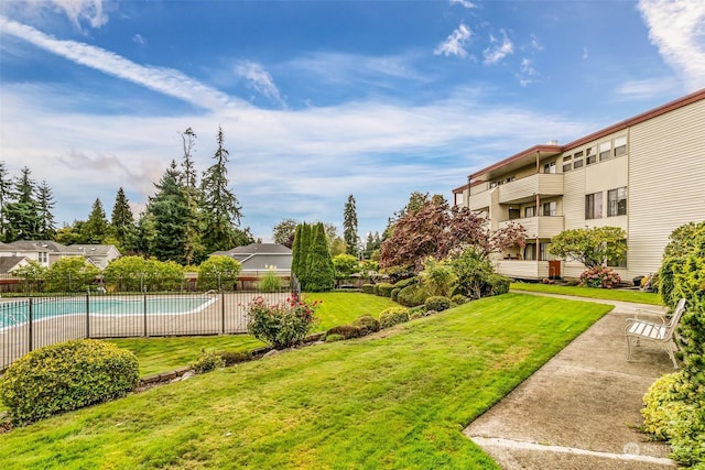 view of property's community featuring a swimming pool and a yard