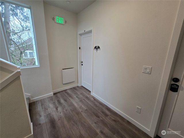 hallway with hardwood / wood-style flooring and heating unit