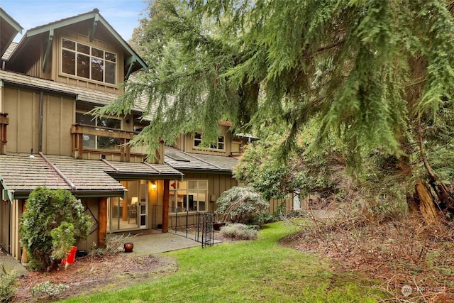 back of property featuring a yard and a patio