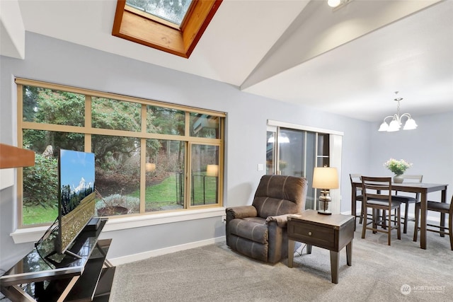 carpeted living room with a wealth of natural light, vaulted ceiling with skylight, and a notable chandelier