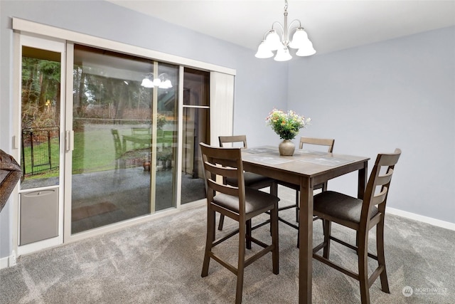 carpeted dining area featuring a chandelier