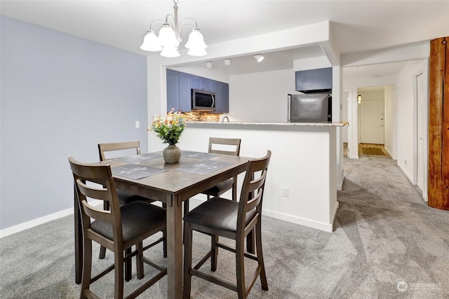 dining room with light carpet and an inviting chandelier