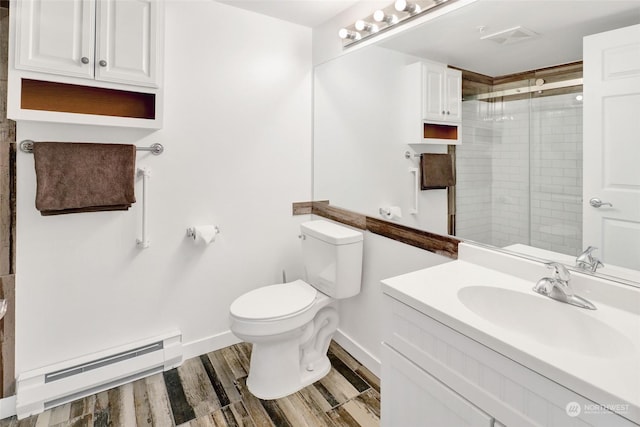 bathroom featuring toilet, vanity, wood-type flooring, baseboard heating, and a shower with door