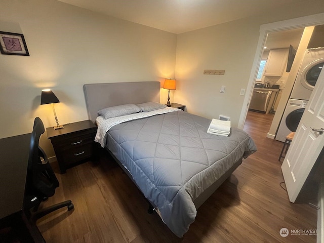 bedroom featuring stacked washer and clothes dryer and dark hardwood / wood-style floors