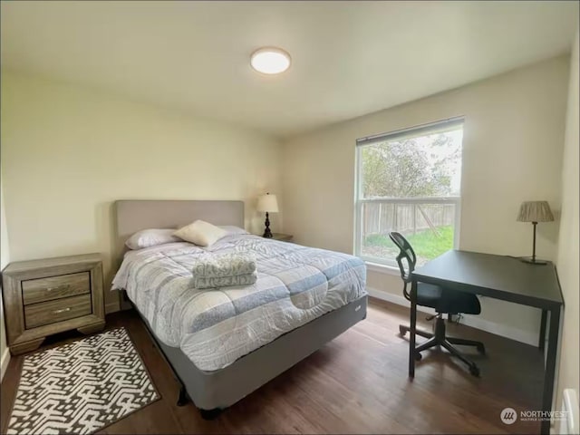 bedroom with multiple windows and dark hardwood / wood-style flooring