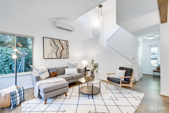 living room with light wood-type flooring and an AC wall unit