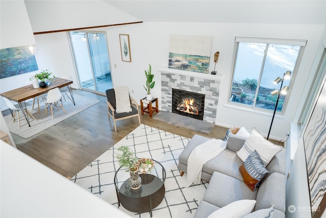 living room featuring a tiled fireplace and hardwood / wood-style floors