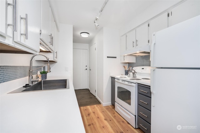 kitchen with sink, white cabinets, track lighting, white appliances, and light hardwood / wood-style floors