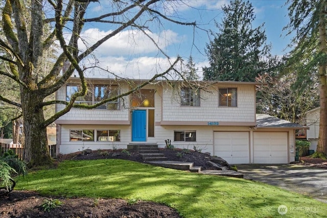 split foyer home with a garage, aphalt driveway, and a front yard