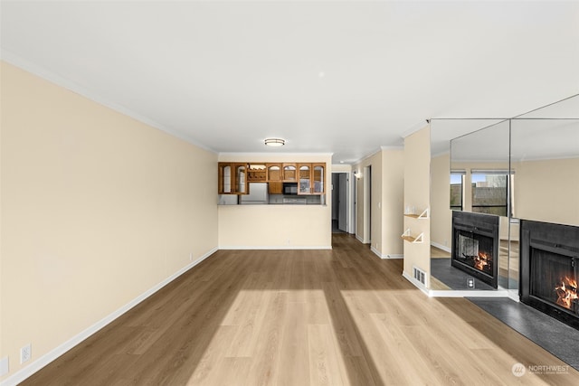 unfurnished living room featuring light hardwood / wood-style flooring and ornamental molding