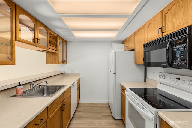 kitchen with sink, white appliances, and light wood-type flooring