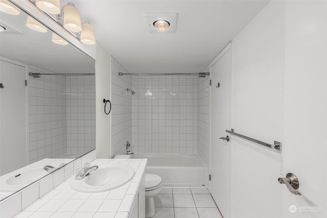 full bathroom featuring toilet, vanity, tiled shower / bath, and tile patterned flooring