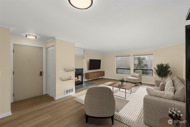 living room with crown molding and light wood-type flooring