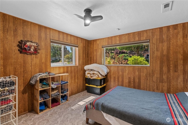 bedroom with ceiling fan, carpet, multiple windows, and a textured ceiling