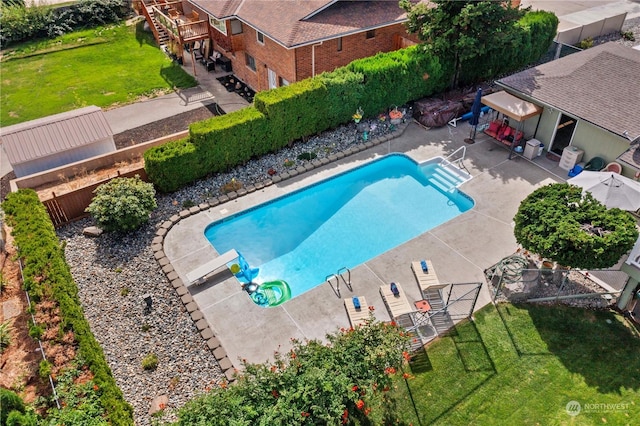 view of pool featuring a diving board, a patio area, and a yard