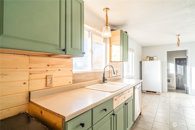 kitchen featuring pendant lighting, refrigerator, dishwasher, sink, and green cabinets