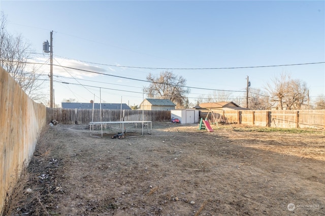 view of yard featuring a shed and a trampoline