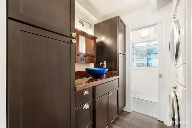 bathroom featuring stacked washer / drying machine, hardwood / wood-style floors, and vanity