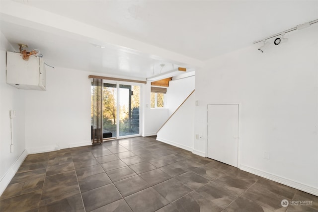 unfurnished room featuring track lighting