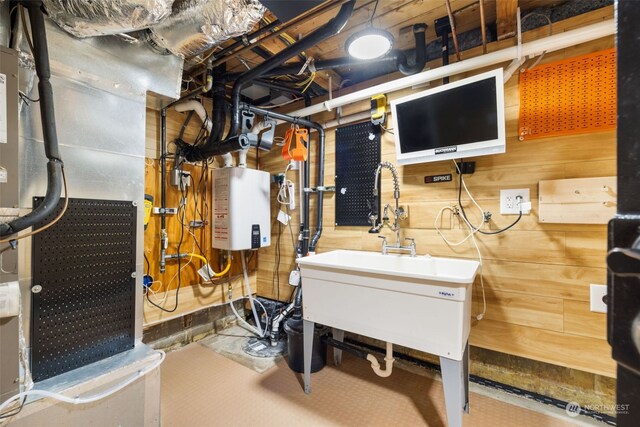 utility room with heating unit, sink, and water heater