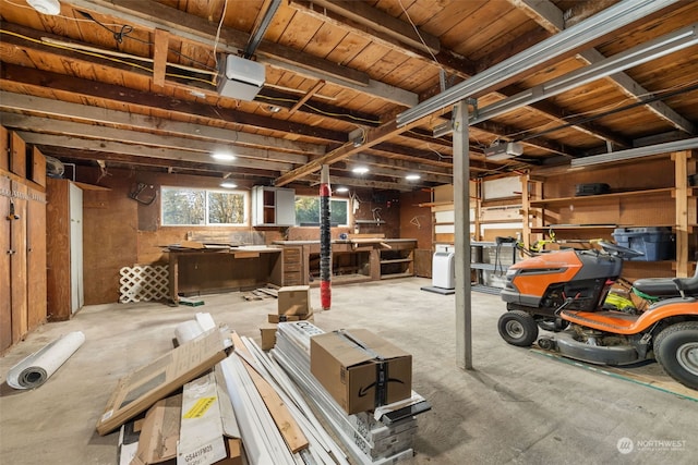 garage featuring a garage door opener, a workshop area, and wooden ceiling