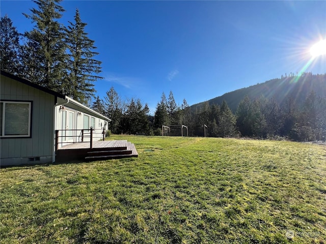 view of yard with a deck with mountain view