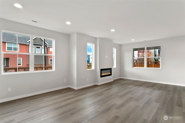 unfurnished living room with a wealth of natural light and hardwood / wood-style floors