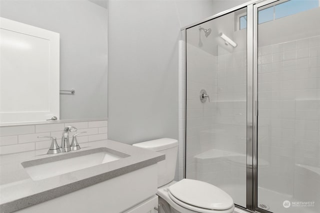 bathroom with toilet, tasteful backsplash, an enclosed shower, and vanity