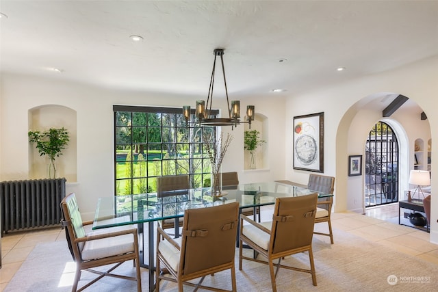 dining room with radiator, light tile patterned floors, and a chandelier