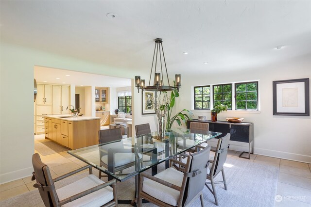 tiled dining area featuring sink and a notable chandelier