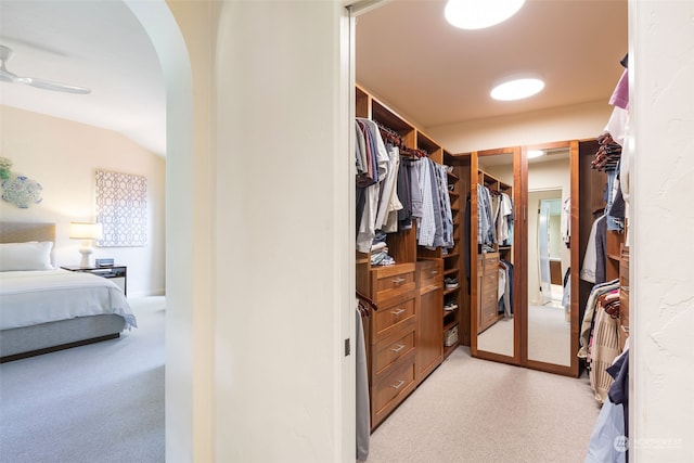 spacious closet featuring lofted ceiling, light carpet, and ceiling fan